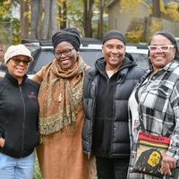 Four people gathered outdoors smiling at the camera