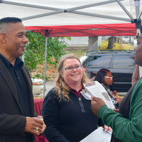 Craig Taylor and Amie Mondl speak with a youth leader outdoors