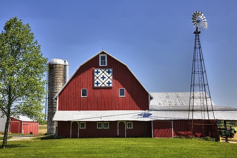 Red dairy barn with silo and windmill on a farm