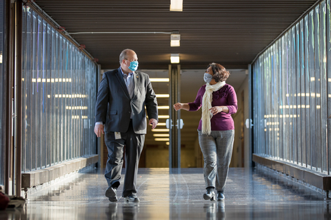 Claudia Gonzales-George walking down a hallway meeting with Northfield Schools Superintendent Matt Hillman