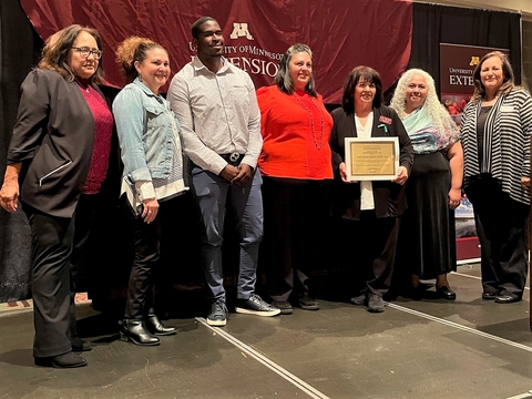 I Can Prevent Diabetes team of six stands on stage holding award plaque with the dean Bev Durgan