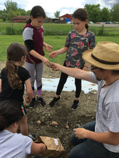 Zachary Page giving lesson on root vegetables to youth.