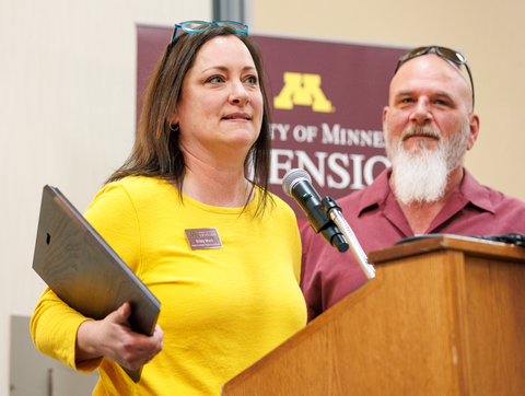 Award winner holding plaque and her spouse by her side at altern