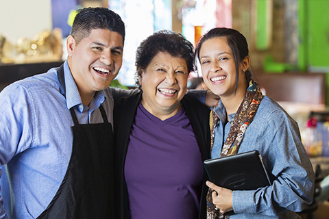 Three Latino adults smiling