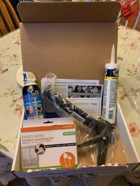 Box containing caulk, caulk gun, spring insulation and window insulating kit and informational documents.