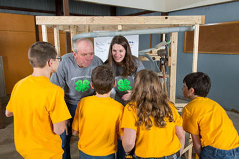 Volunteers and 4-H'ers working on Rube Goldberg project