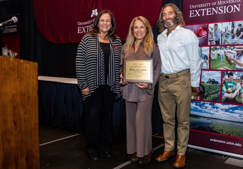 Dean Bev Durgan on the left, then Milena holds her award plaque and her husband is on her other side.