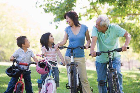 Mother, grandfather and two children biking