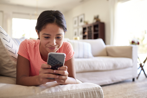 Girl looking at cell phone at home