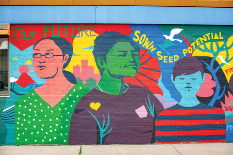 Mural on wall of three people and nature