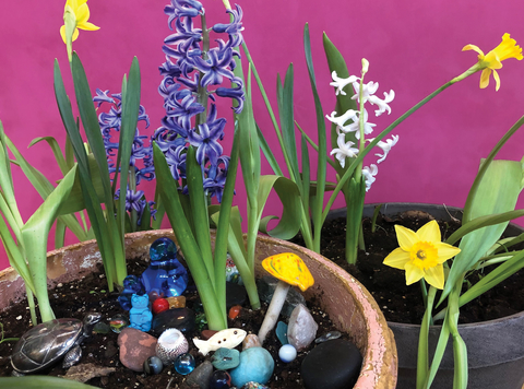 Flowerpot with blooming spring flowers and small decorative items