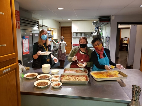 Health and nutrition educators cooking and serving food at Vail Place. 