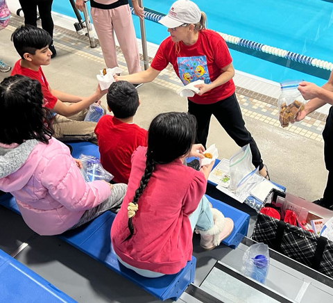 Youth sitting in the bleachers at an indoor swimming pool