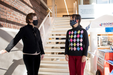 Elizabeth Yang and Teresa Jensen chatting on a staircase.