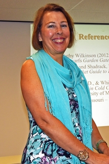 Master Gardener has her presentation on a large screen behind her