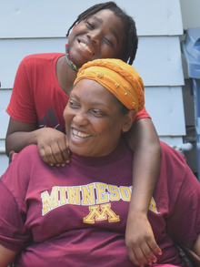 Sheronda Orridge smiles as a youth crew member stands behind her with their arms draped over her shoulders