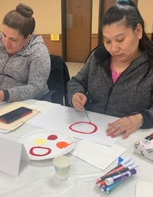 Two program participants work on an art activity