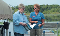 two women on a lake with a notebook