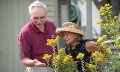 Man and woman looking at flowers outside