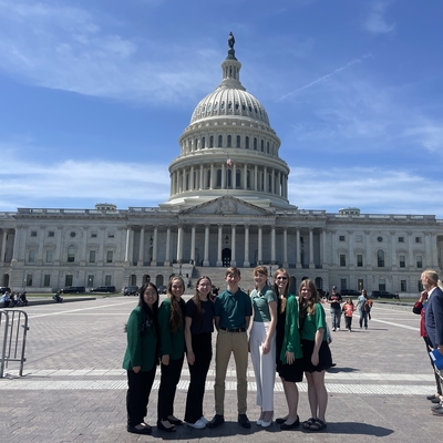 7 youth stand in front of the U.S. Capitol