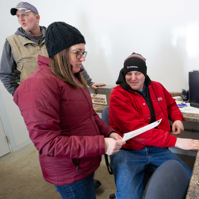 Three people discussing a dairy business plan.