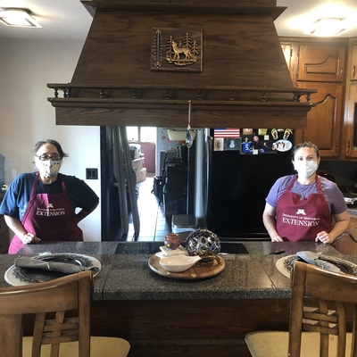 Health and nutrition educators set up a cooking demo in a home kitchen