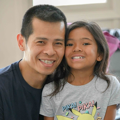 Father and daughter smile for the camera together