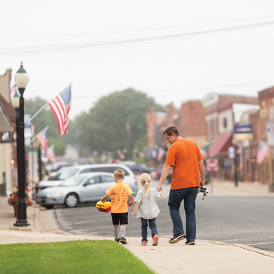 father walking children in small town