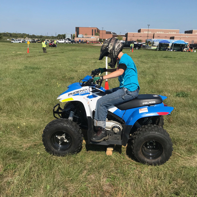 Boy riding a blue ATV.