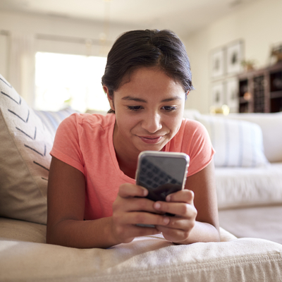 girl looking at cell phone at home