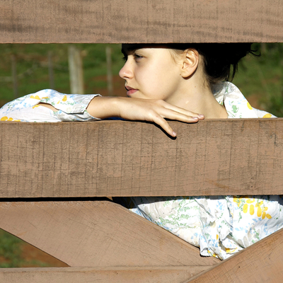 girl behind farm fence