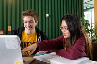 Two teens looking at a laptop